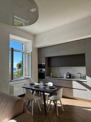 Una cocina y una sala de estar con mesa y sillas. en Alocasia luxury stay, en Salerno