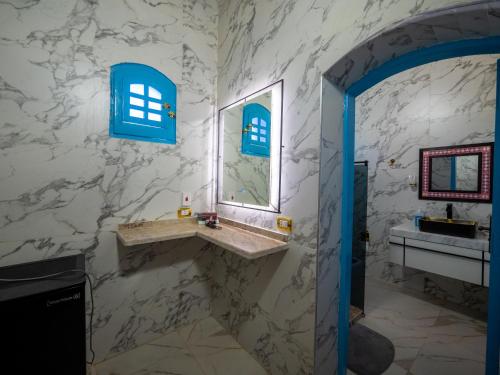 a bathroom with a sink and a mirror at B&W SAHARA SKY CAMP in Qasr Al Farafirah