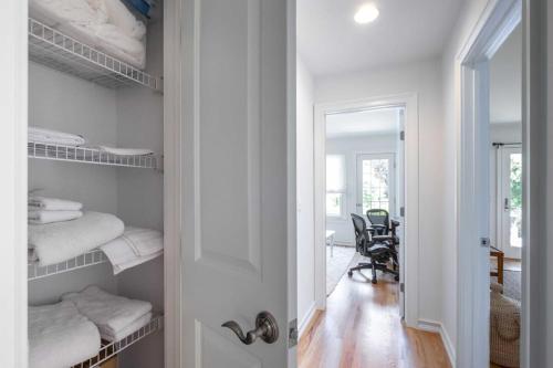 um quarto com um armário com toalhas nas prateleiras em Heated Pool, Driftwood Cottage by RoveTravel em East Hampton
