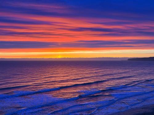 una puesta de sol sobre el océano en la playa en Filey Beach House, en Filey