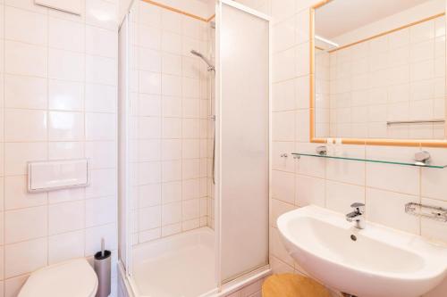 a white bathroom with a sink and a shower at Hochwertig einger. Fewo mit Sonnenterrasse, Veranda, in Strandnähe in Kühlungsborn