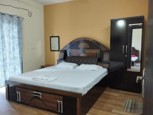 een slaapkamer met een groot bed en een spiegel bij Née Barsha residency in Puri