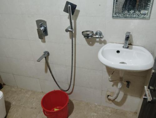 een badkamer met een douche, een wastafel en een emmer bij Née Barsha residency in Puri