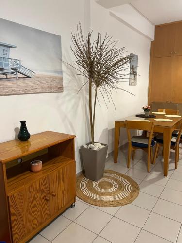 a living room with a table and a potted plant at Makenzie 2 rooms first line beach in Larnaca
