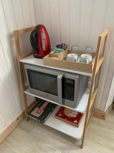 a microwave on a shelf in a kitchen at La petite échappée in Gérardmer