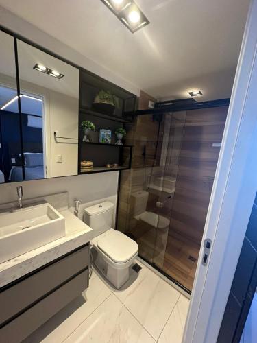 a bathroom with a shower and a toilet and a sink at Unity Suites Beira Mar in João Pessoa