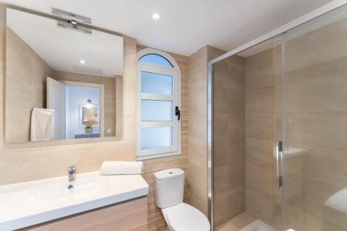 a bathroom with a toilet and a sink and a shower at Billy's Puerto de Mogán Apartments by LIVVO in Puerto de Mogán