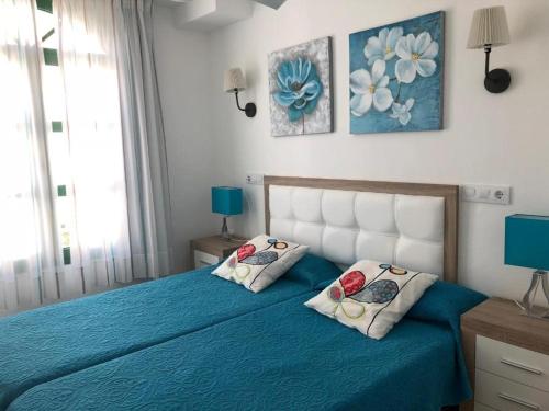 プエルト・デ・モガンにあるBilly's Puerto de Mogán Apartments by LIVVOのベッドルーム1室(青いベッド1台、枕2つ付)