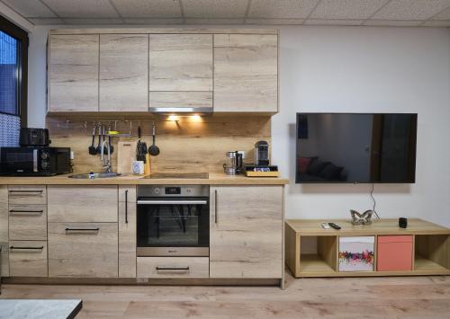 a kitchen with wooden cabinets and a tv on the wall at Sleep1c in Hamburg