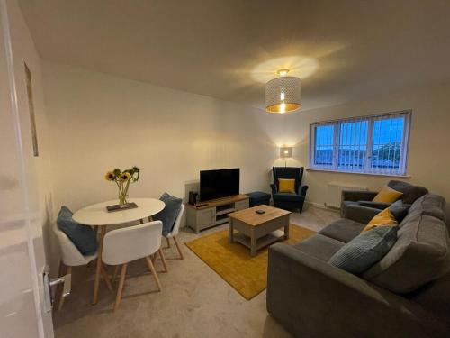 een woonkamer met een bank en een tafel bij 2 bedroom luxury flat in quiet village of Bishopton in Bishopton