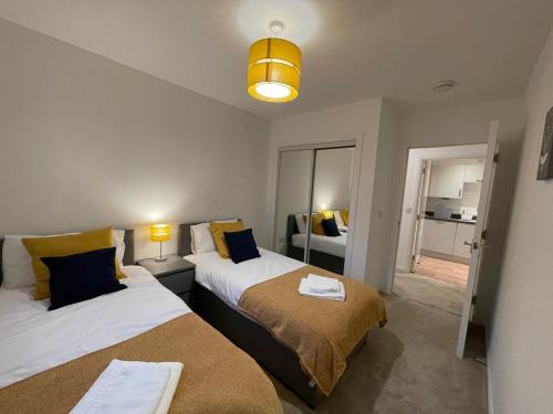 a bedroom with two beds and a room with a window at 2 bedroom luxury flat in quiet village of Bishopton in Bishopton