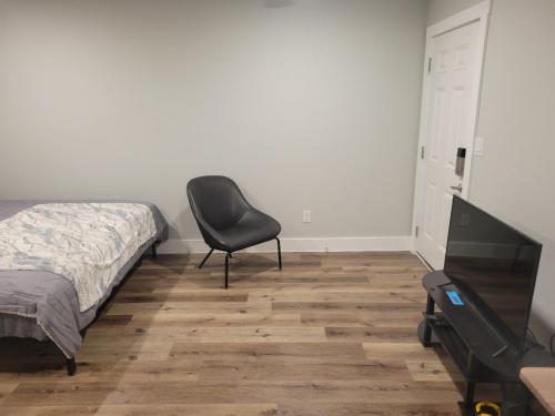 アルバンにあるThe Place To Stayのベッドの横に椅子が備わるベッドルーム1室