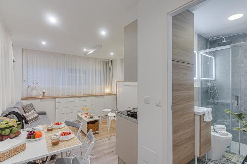 a kitchen and dining room with a table and a bathroom at Super Centro y Playa by TheBlueWaveApartments com in A Coruña
