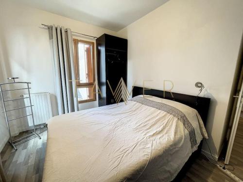 ein Schlafzimmer mit einem großen Bett in einem Zimmer in der Unterkunft Cocon urbain in LʼÎle-Saint-Denis