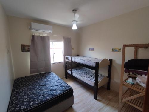a room with two bunk beds and a window at Casa de Praia do Adriano in Itapoa