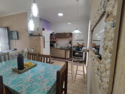 a kitchen and living room with a table and chairs at Casa de Praia do Adriano in Itapoa