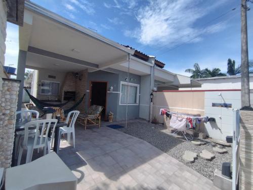 a patio of a house with a table and chairs at Casa de Praia do Adriano in Itapoa