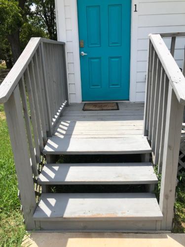 una puerta azul en una casa con escaleras en The Place To Stay, en Alvin