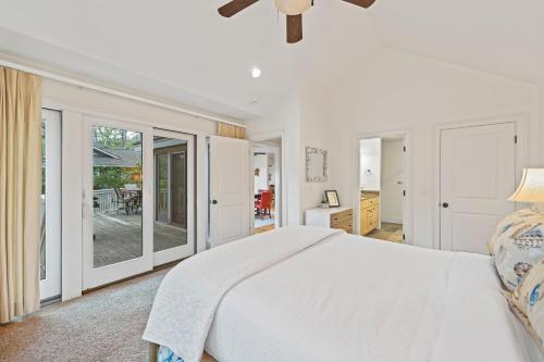 a white bedroom with a large bed and sliding glass doors at 152 Augusta National in Kiawah Island