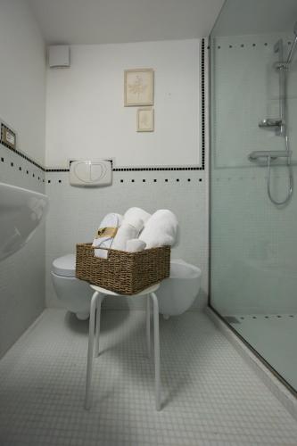 a bathroom with a toilet and a basket of towels at Palazzo Gessi Room and Breakfast in Borghi