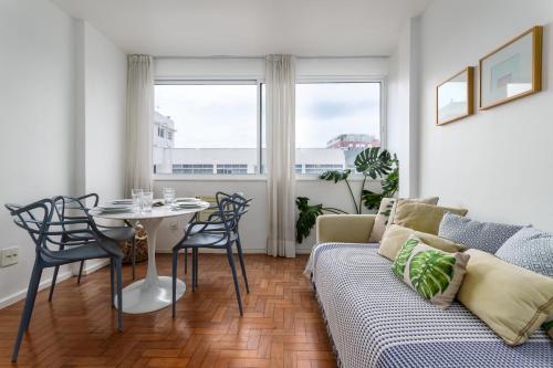 een woonkamer met een bank en een tafel bij Unhotel - Perfeito Apartamento Temporada no Leblon, Perto da praia in Rio de Janeiro