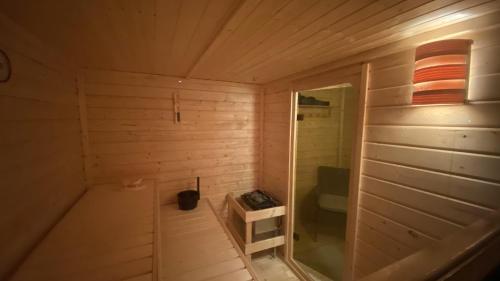 a small wooden room with a sauna with a toilet at Tiny House mit Sauna am See in Repente