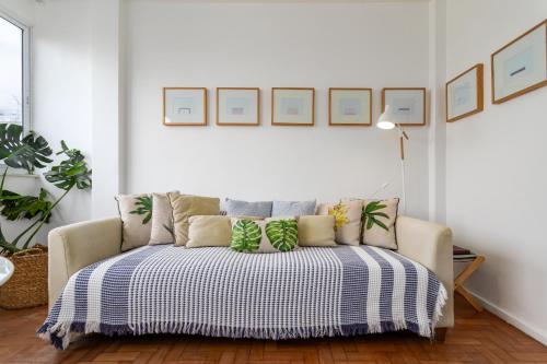 een slaapkamer met een bed met een gestreepte deken bij Unhotel - Perfeito Apartamento Temporada no Leblon, Perto da praia in Rio de Janeiro