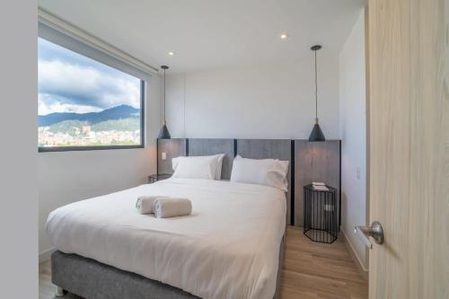 a bedroom with a large white bed with a window at Classy 1BR in Chapinero in Bogotá
