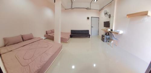 a room with a bed and a couch and a chair at Lynn Living (ลินน์ ลิฟวิ่ง) in Ban Non Muang
