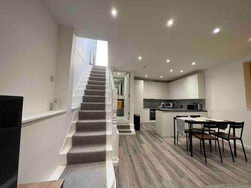 a staircase in a kitchen with a table and chairs at Stunning 3BR Maisonette in Brixton in London