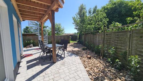 a patio with a table and a fence at Haus Wolkentraum - Fewo Traum mit Terrasse und Bio-Kamin in Zinnowitz