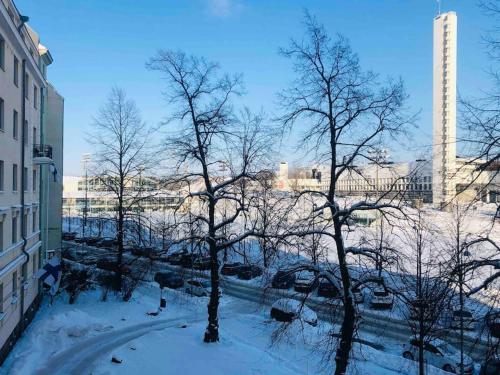 a group of trees in the snow in a city at Charming apartment in Töölö with Nordic design in Helsinki