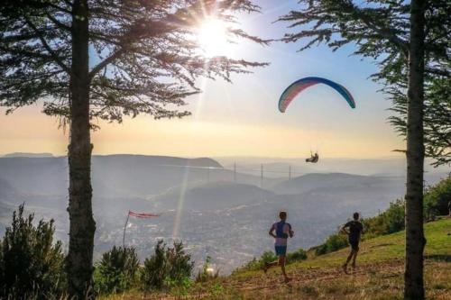 Dos personas de pie en una colina volando una cometa en Quai 36, en Millau