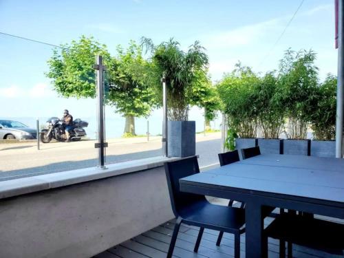 a table and chairs on a patio with a view of a street at Superbe cocon en bord du lac in Publier
