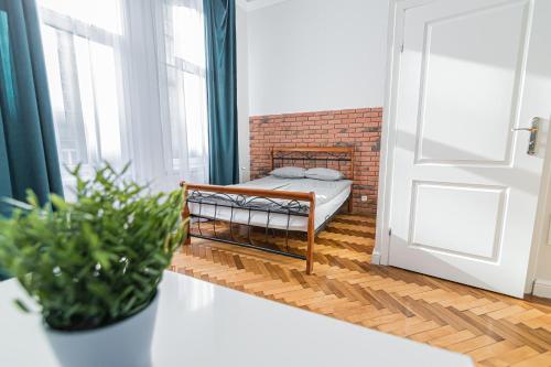 niewielka sypialnia z łóżkiem i ceglaną ścianą w obiekcie ROYAL Apartments w Krakowie
