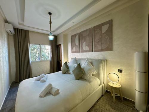 een slaapkamer met een groot wit bed met 2 kussens bij Bel Appart Familial Majorelle in Marrakesh