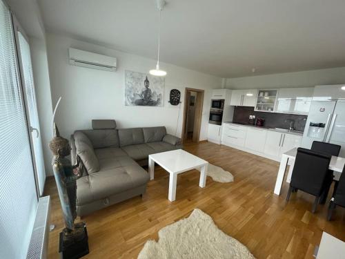 a living room with a couch and a table at Dvojizbový byt vzdialený 800 m od X Bionic Sphere s dvoma kúpeľňami in Šamorín