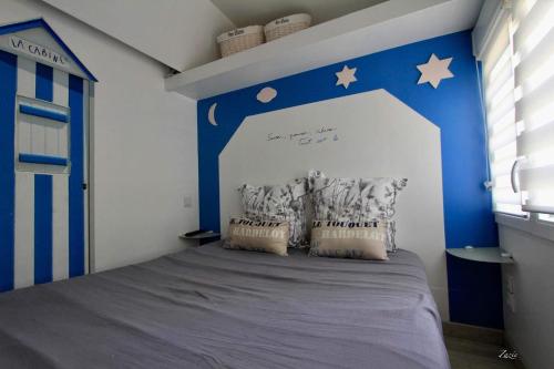 een blauwe en witte slaapkamer met een bed met sterren erop bij EPICETOUT in Dannes
