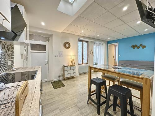 Una cocina con encimera y taburetes en una habitación. en Quai 36, en Millau