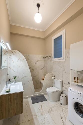 a bathroom with a toilet and a sink and a tub at Loukoumi in Ermoupoli