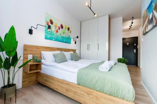1 dormitorio con 1 cama blanca grande y escritorio en City Center - AURA by Apartmore en Gdansk