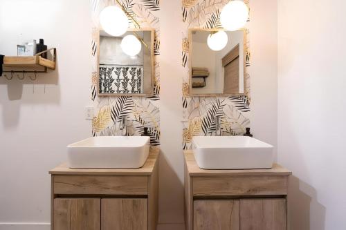 two sinks in a bathroom with two mirrors at Fantastic Island House 1 mile to the beach with heated pool in Sarasota