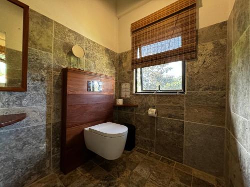 a bathroom with a toilet and a window at Ciel y Miel in Colón