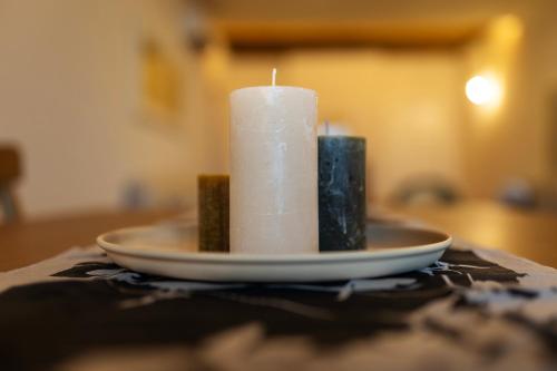 a candle on a plate on a table at Palazzo Gessi Room and Breakfast in Borghi