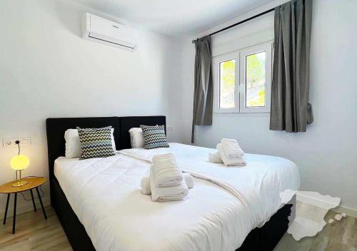 um quarto com uma cama grande com lençóis brancos e almofadas em CostaBlancaDreams Bernia Views in Calpe em Empedrola