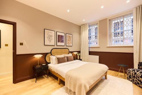 a bedroom with a bed and two windows at The Bayswater Gardens - Bright 3BDR Home in London