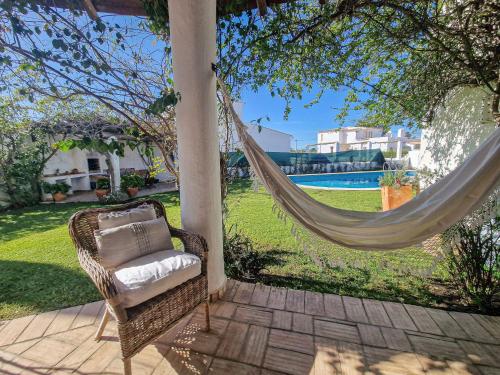 a hammock on a patio with a view of a yard at Villa Vale de Ursa - 16 - BY BEDZY in Sesmarias