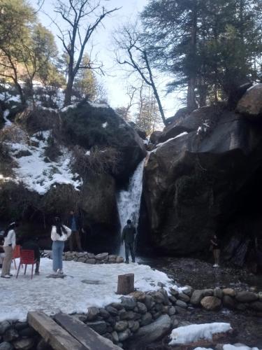 a group of people standing in front of a waterfall at Anand -Giri Retreat in Nagar