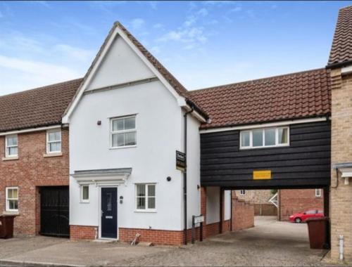 a white house with a black roof at Stylish house centrally located in Bury Saint Edmunds