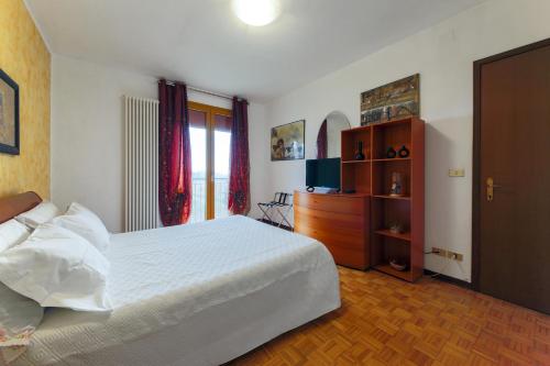 1 dormitorio con cama blanca y vestidor en Free parking - 15 min to Venice en Tessera